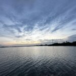 Ein ruhiger Sonnenuntergang über dem Wasser in Cudjoe Key, Florida, mit bewölktem Himmel und stiller Wasseroberfläche.