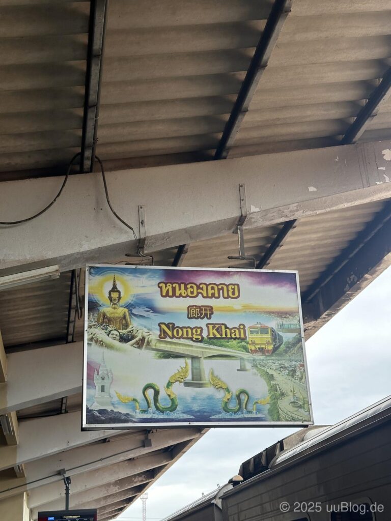 Ein Schild am Bahnhof Nong Khai in Thailand zeigt eine Buddha-Statue, einen Zug und die legendäre Naga-Schlange.