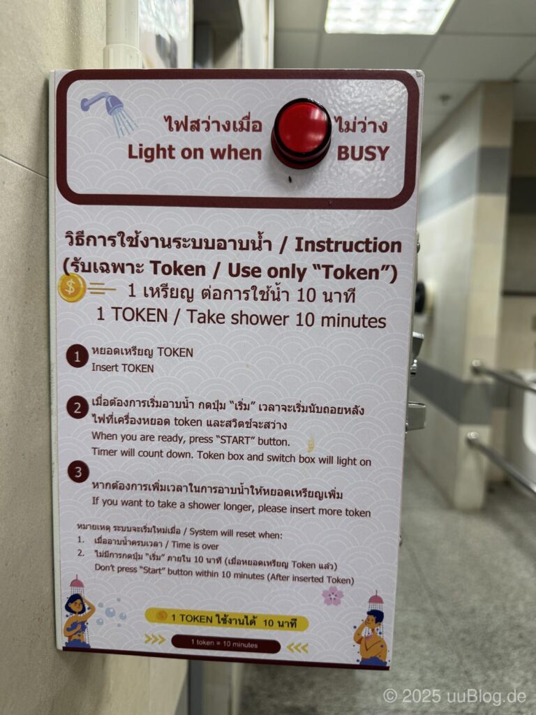 Anleitung für die Nutzung einer Duschanlage mit Token-System und Hinweisen auf englisch und thailändisch.