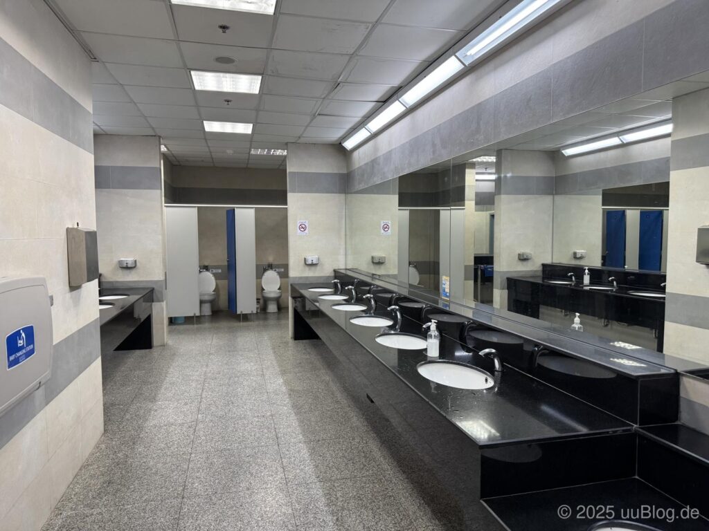 Ein moderner, sauberer öffentlicher Waschraum mit Waschbecken und Toiletten.
